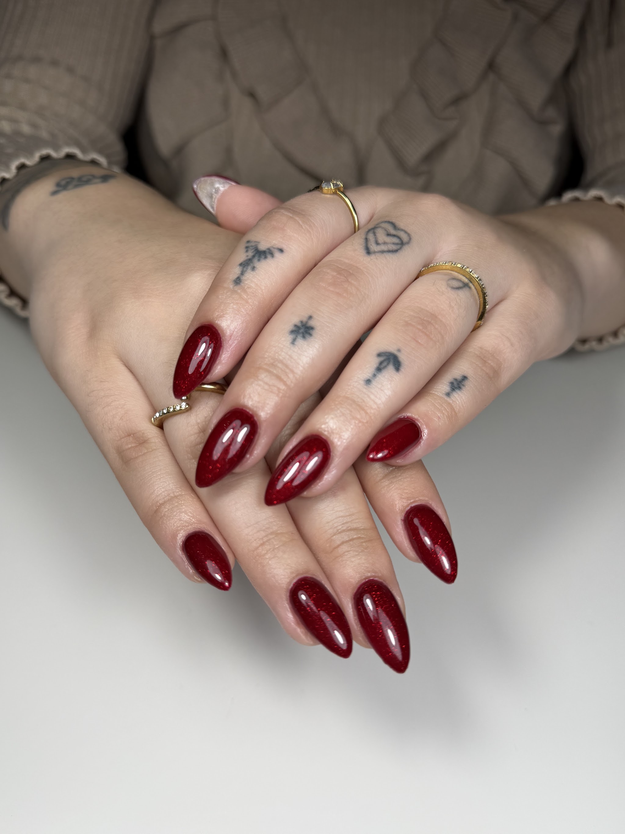 Donkerrode amandelnagels op twee handen