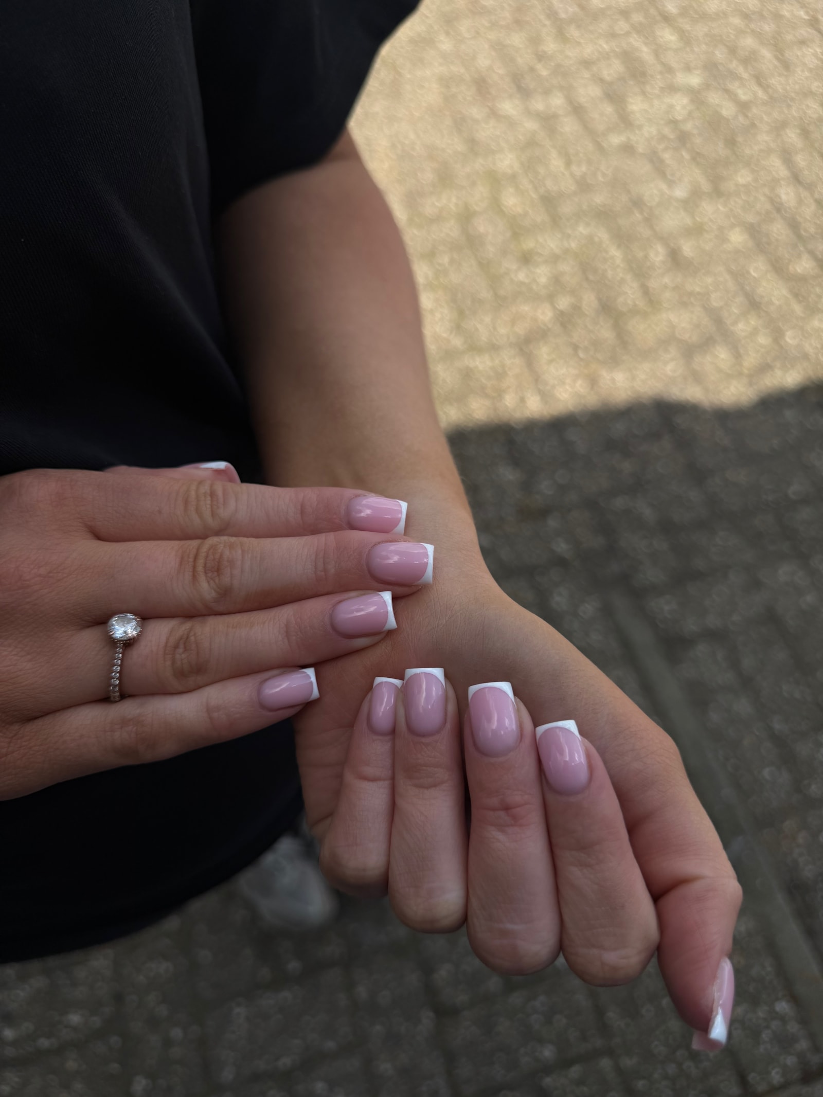 Vierkante nagels met een witte french, buiten in het daglicht